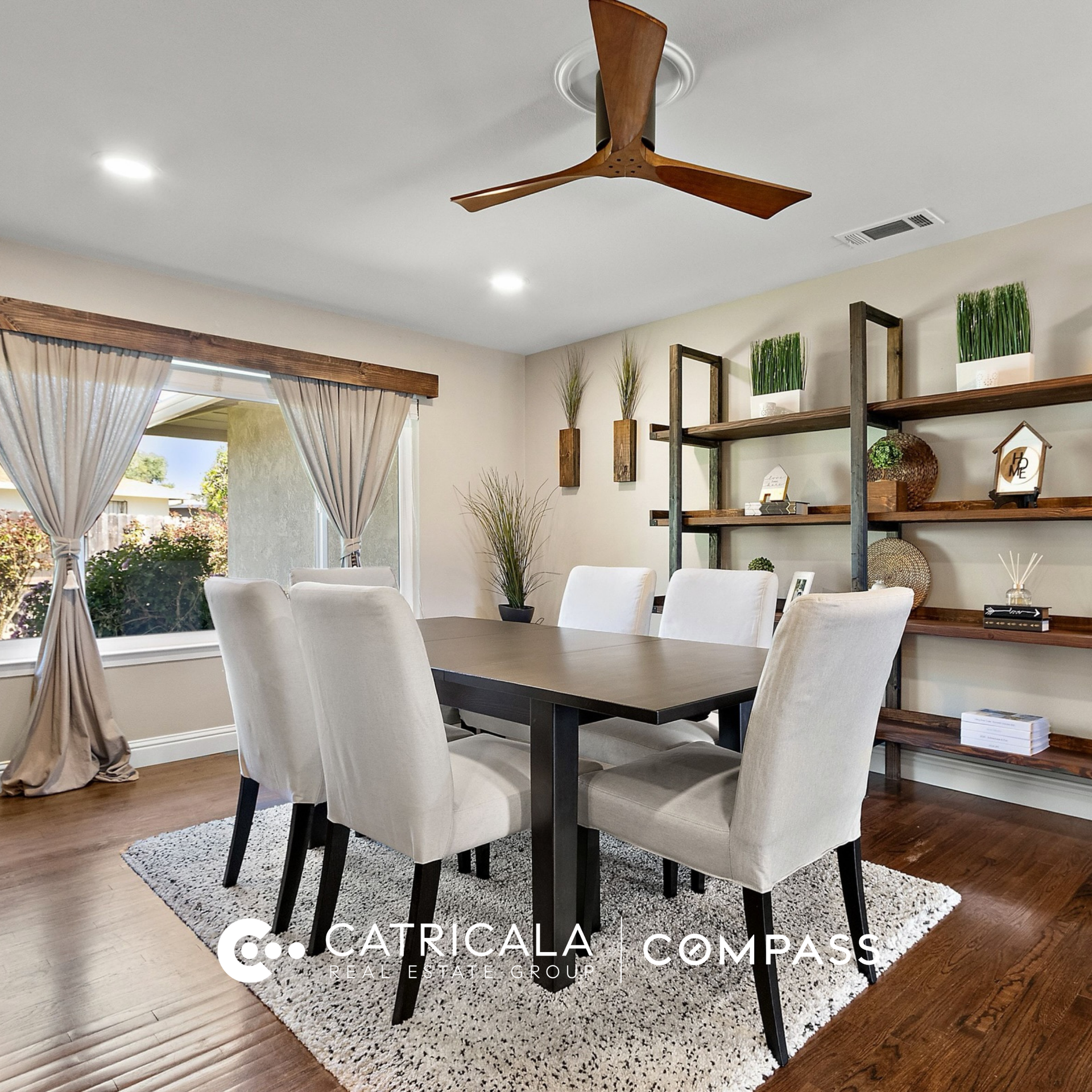 Elegant dining room with wood floors, upholstered chairs, and built-in shelving.