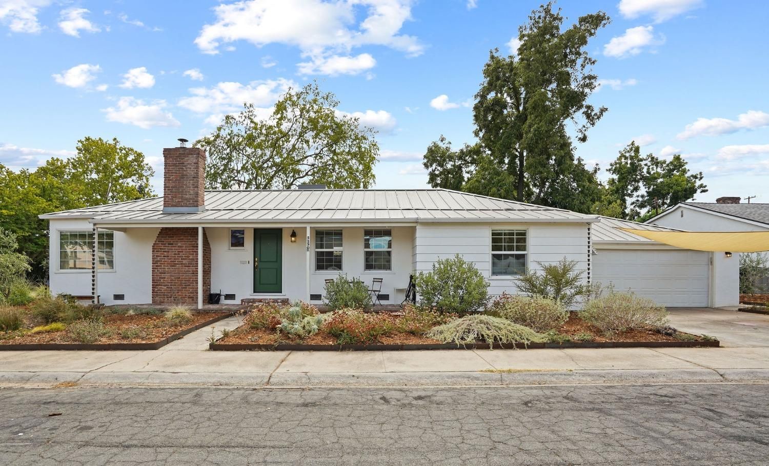 A white house with a green door and a white garage door | Buy a Home in Greenhaven-Pocket, Sacramento, CA