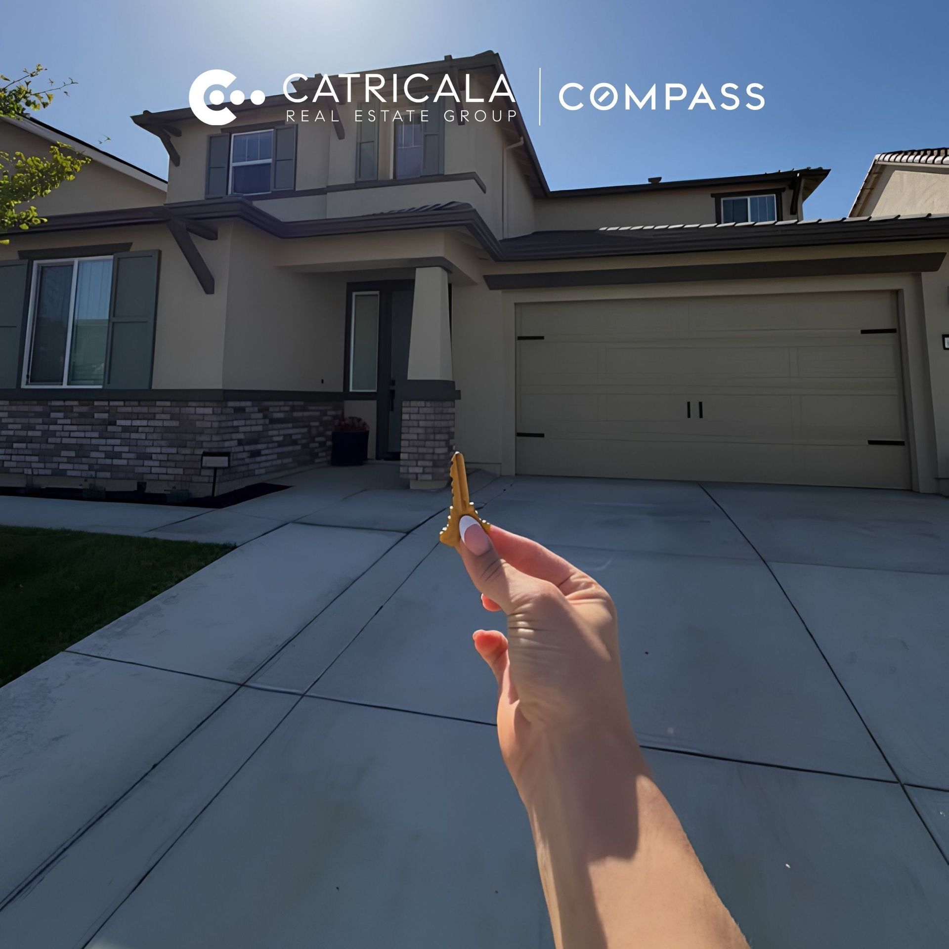 A hand holding a gold house key in front of a modern two-story suburban home, with the Catricala Real Estate Group Compass logo overlayed at the top.