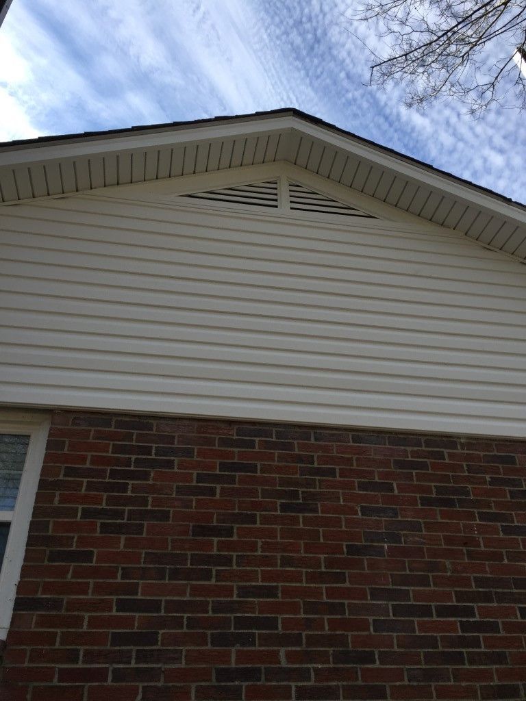 A brick house with a white siding