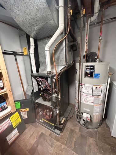 Utility room with furnace, water heater, and exposed ductwork on a tiled floor.