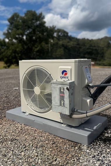 Outdoor HVAC condenser unit on a rooftop under a cloudy sky