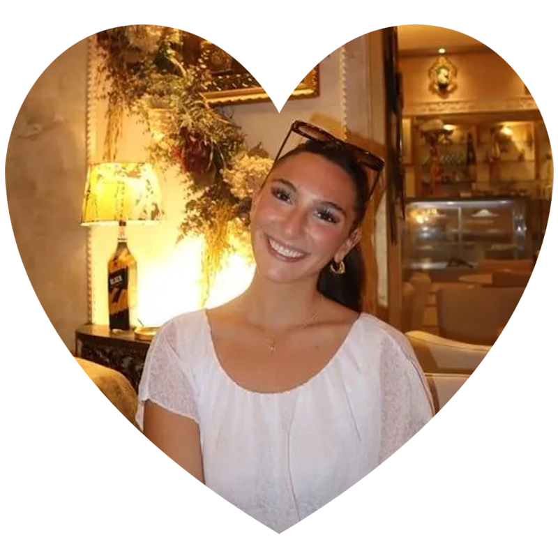 A woman is smiling while sitting at a table in a restaurant A woman is smiling while sitting at a table in a restaurant