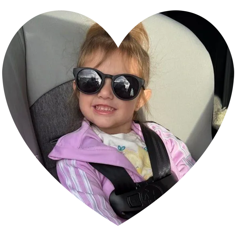A little girl wearing sunglasses is sitting in a car seat holding a stuffed mickey mouse. A little girl wearing sunglasses is sitting in a car seat holding a stuffed mickey mouse.