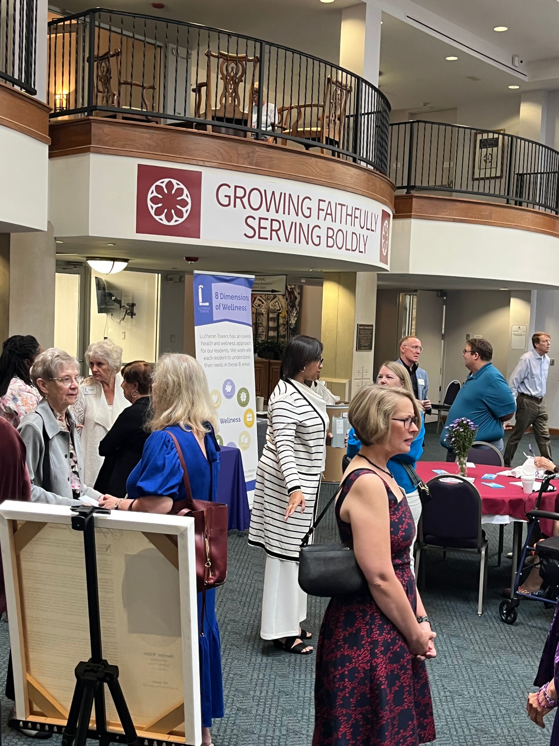 A group of people are standing in a room with a sign that says growing on a serving board.