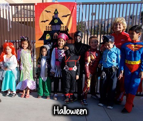 A group of children in halloween costumes pose for a picture