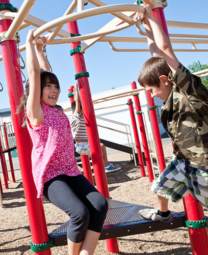 A boy and a girl are playing on a playground