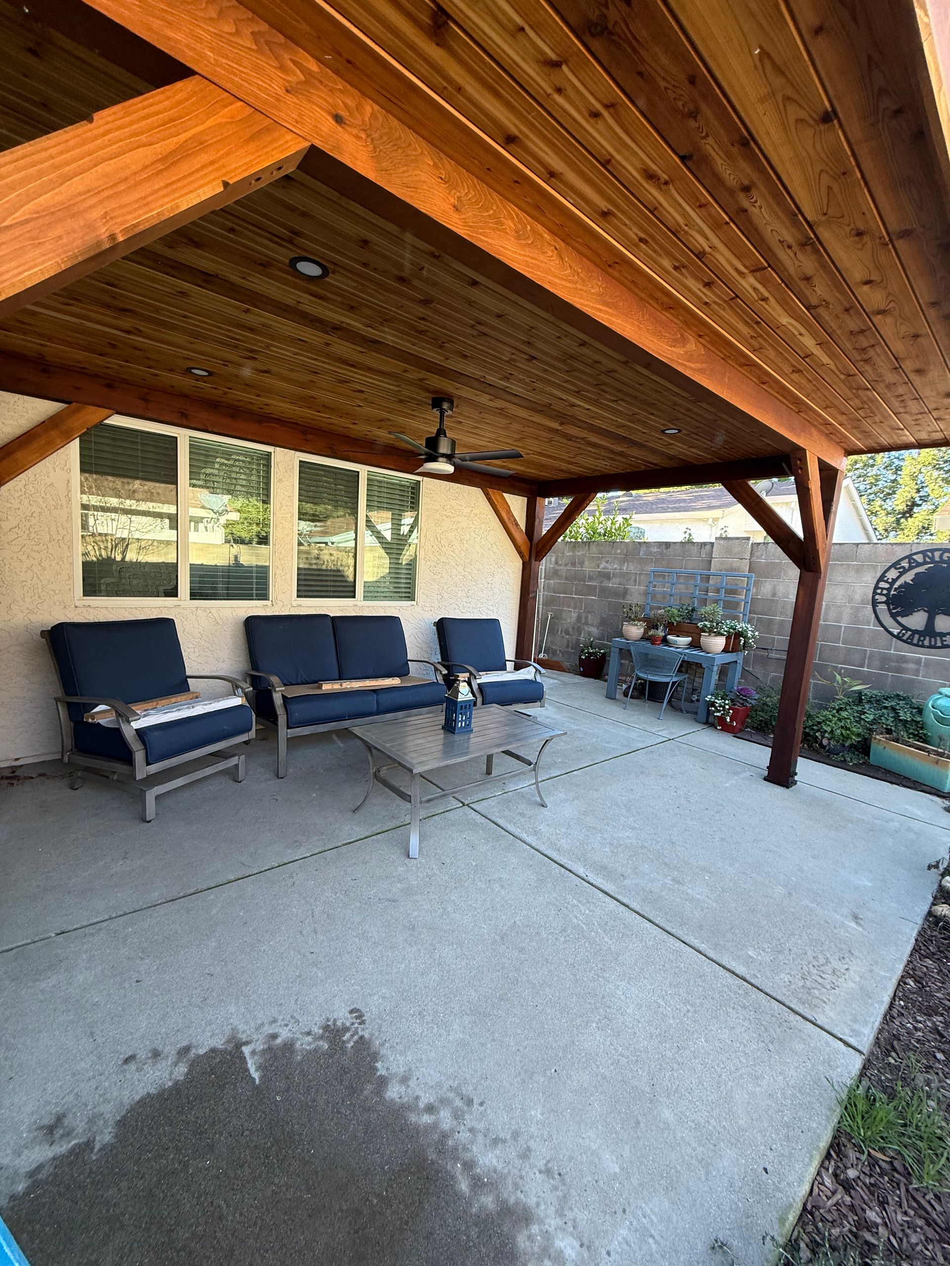 Patio with wooden patio cover, outdoor seating, and concrete floor.