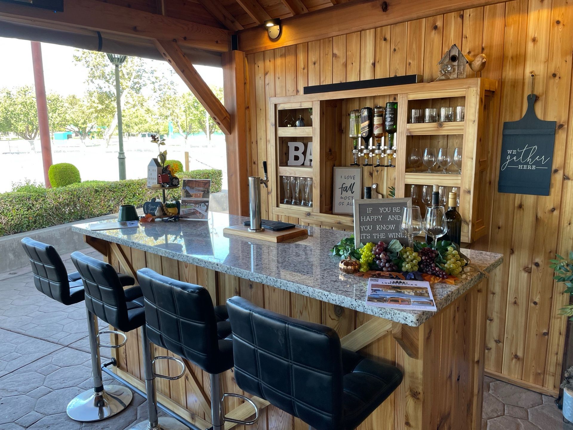 A wooden bar with stools and a chalkboard on the wall.