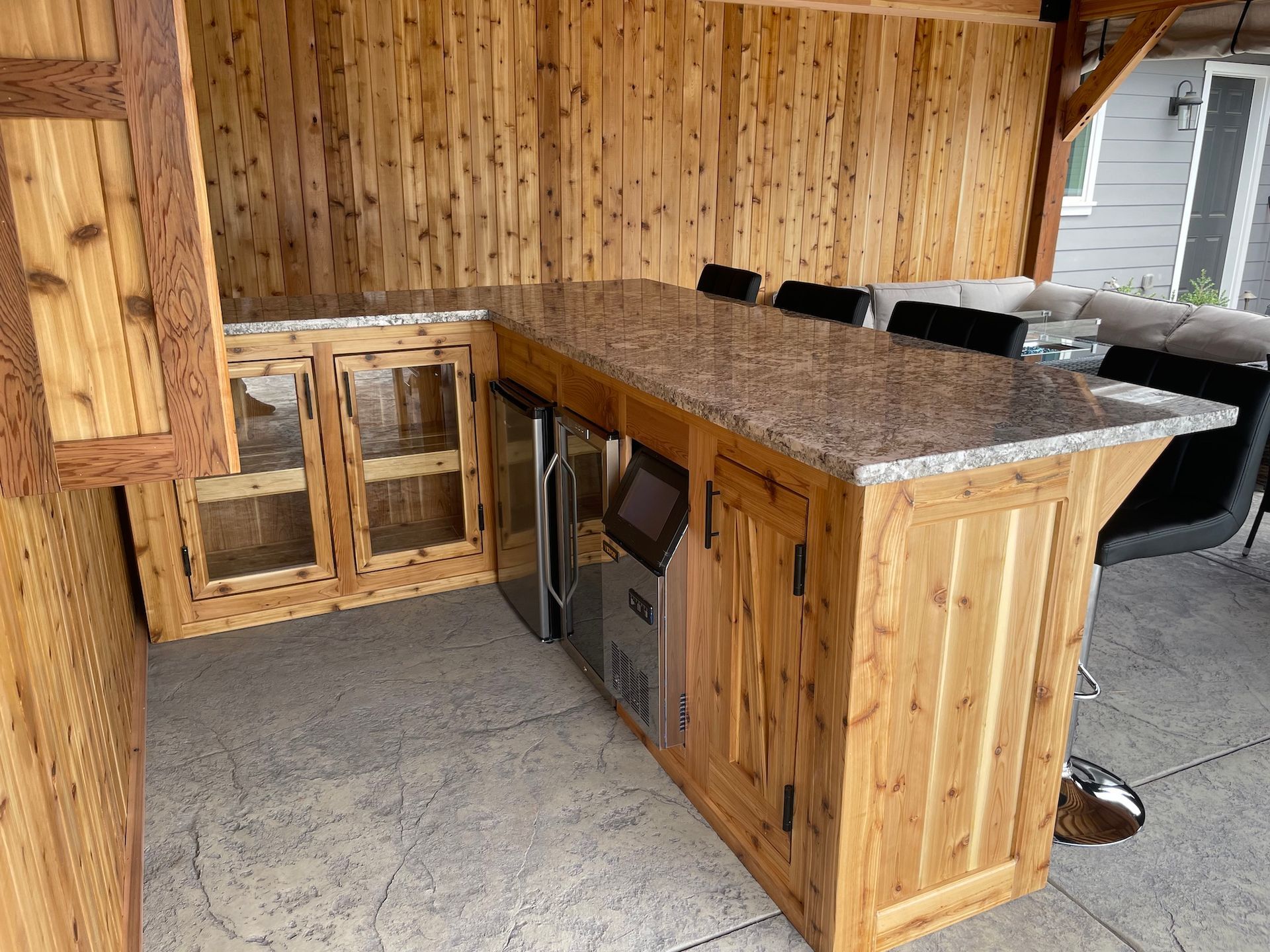 A wooden kitchen with a granite counter top and cabinets.