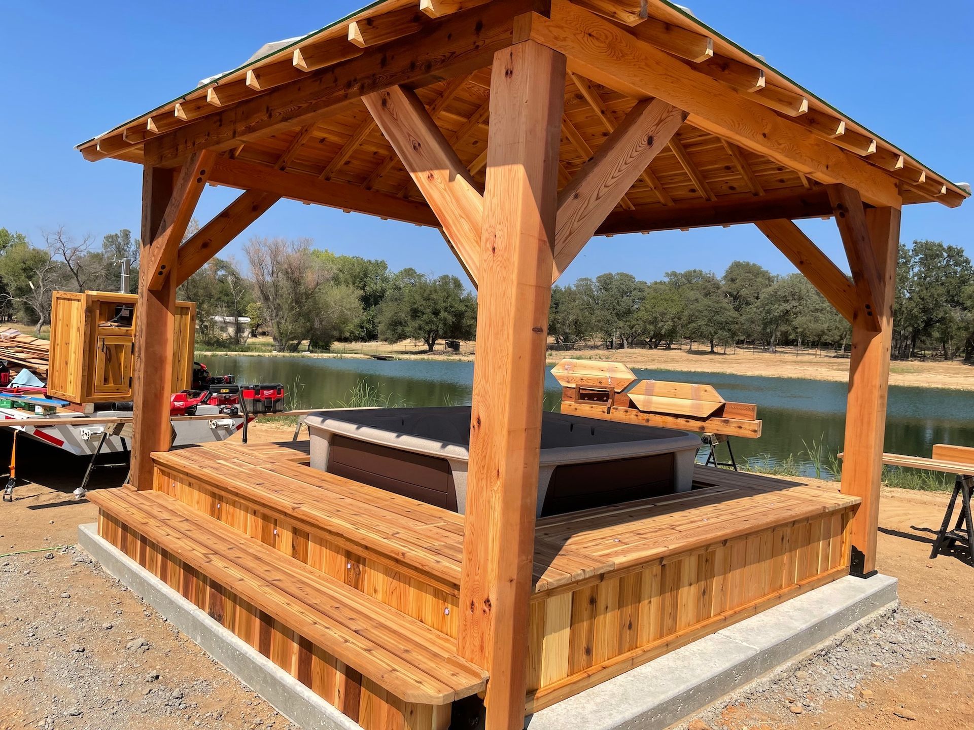 A wooden gazebo with a hot tub inside of it