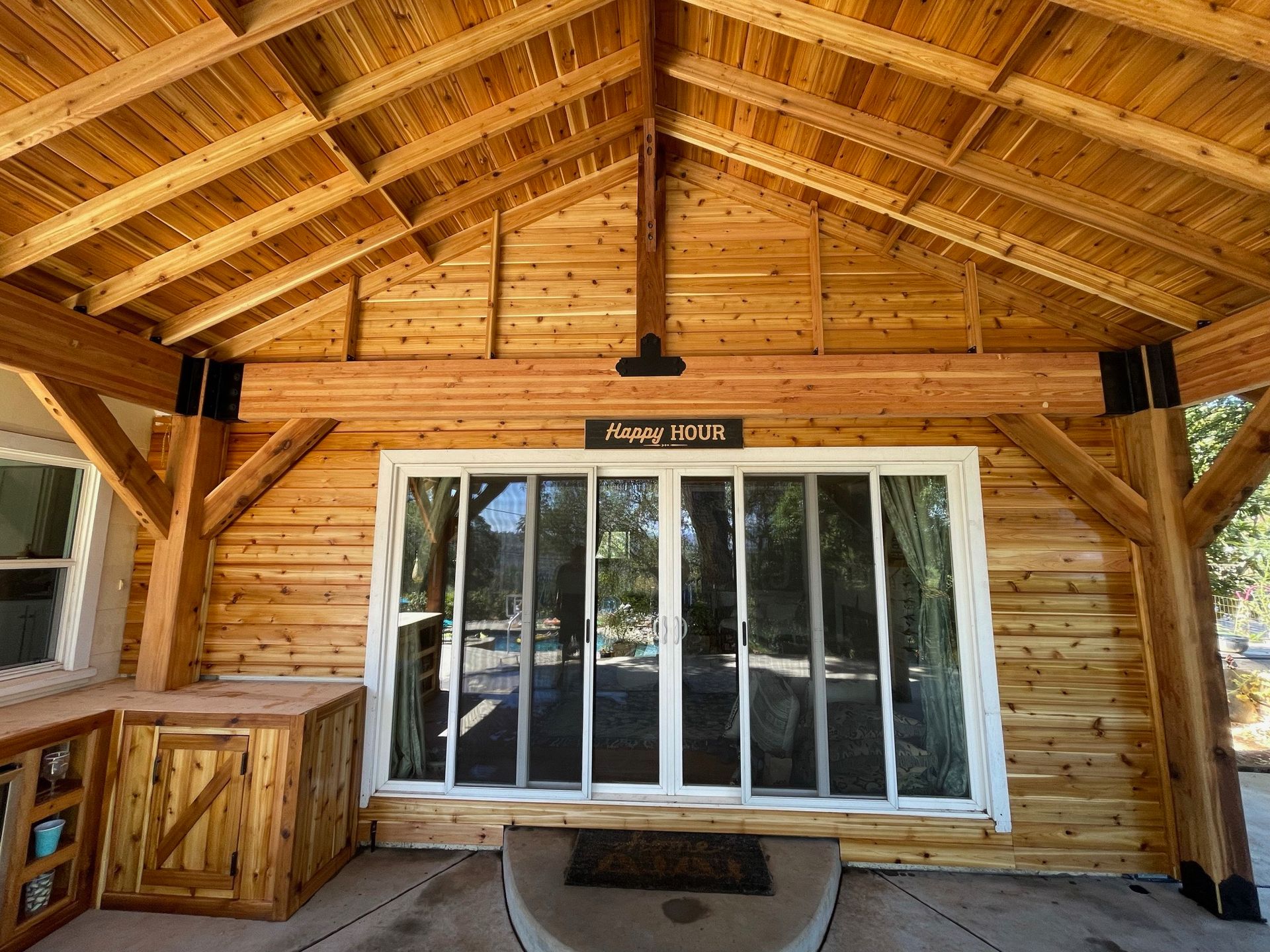 A wooden house with a large window and a wooden roof