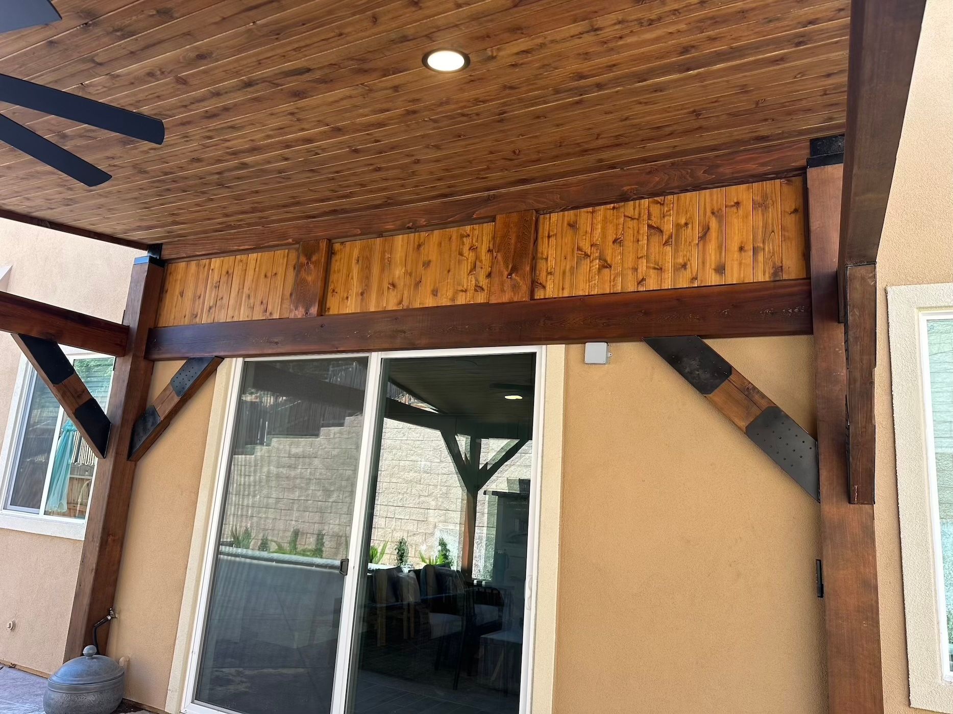 A ceiling fan is hanging from the ceiling above a sliding glass door.