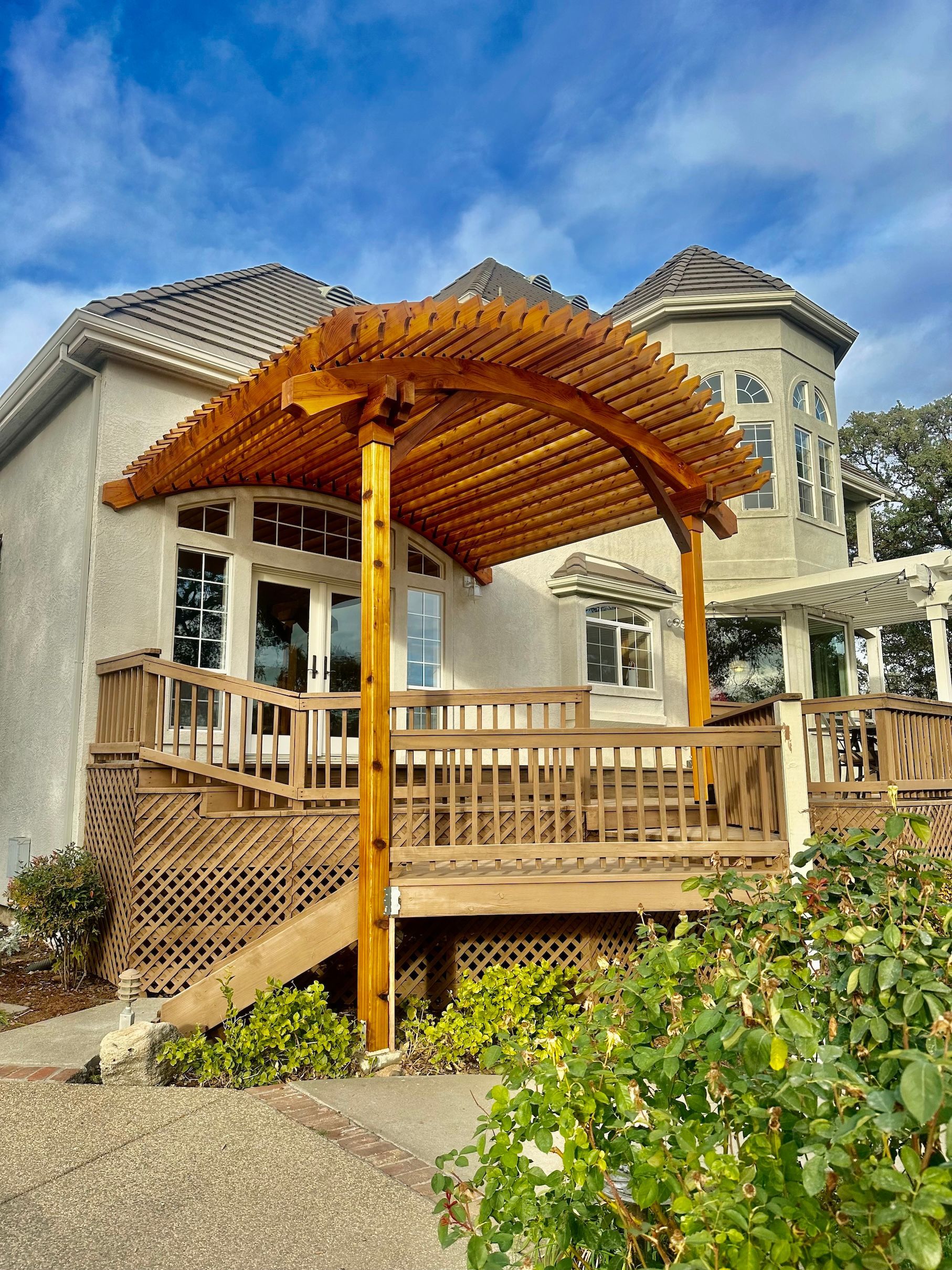 a house with a wooden pergola on the back of it