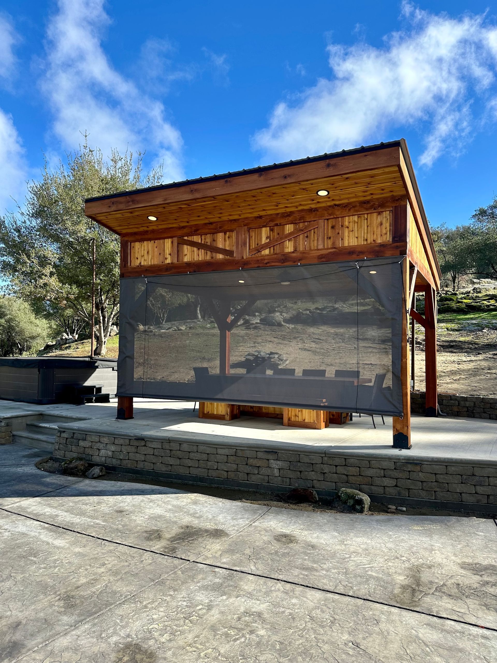 a wooden gazebo with a screen on the side of it .