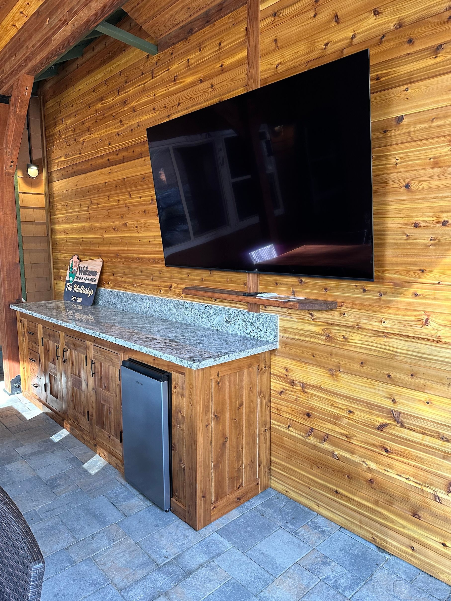 a large flat screen tv is hanging on a wooden wall .