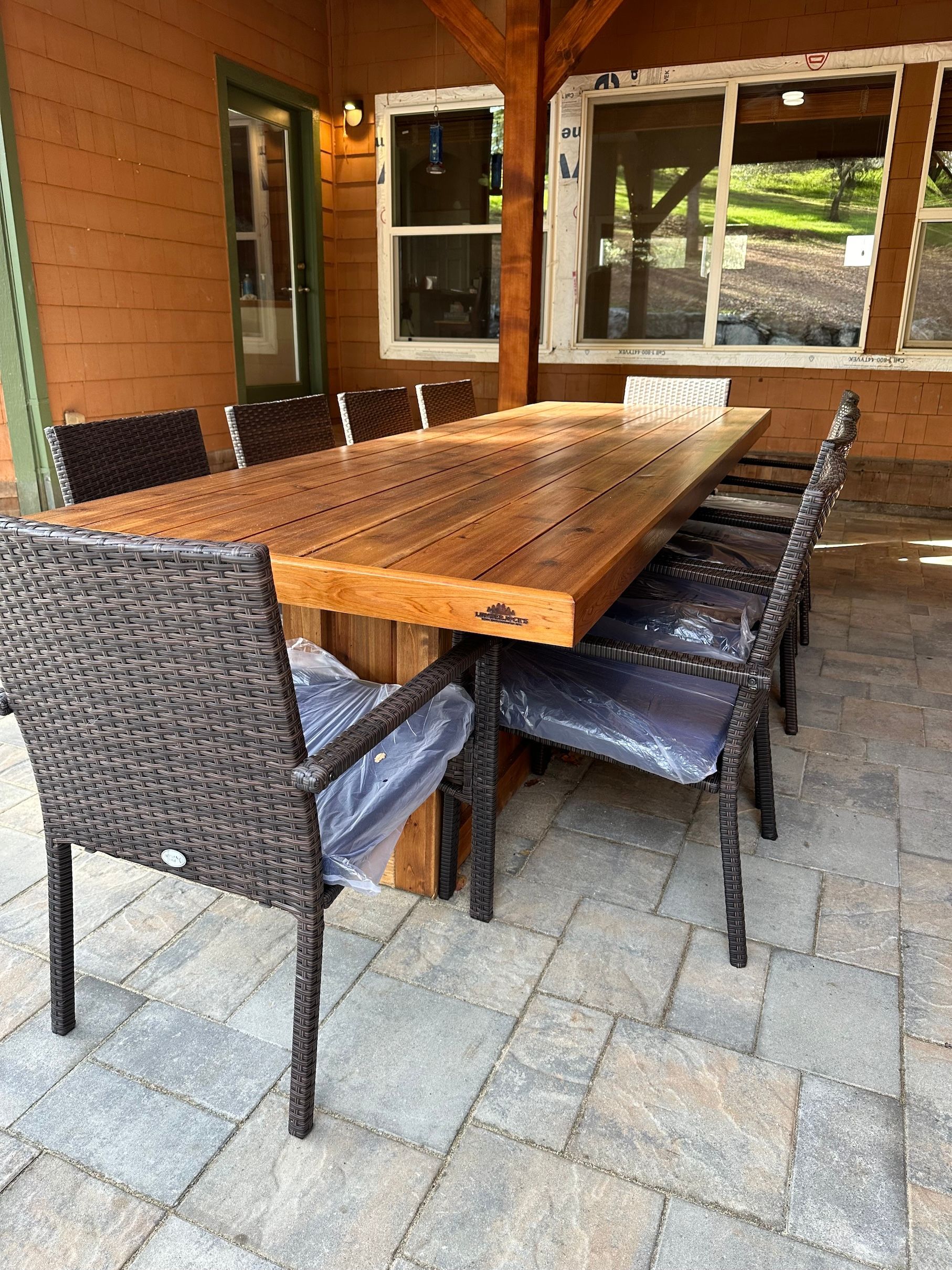a wooden table with wicker chairs on a patio .