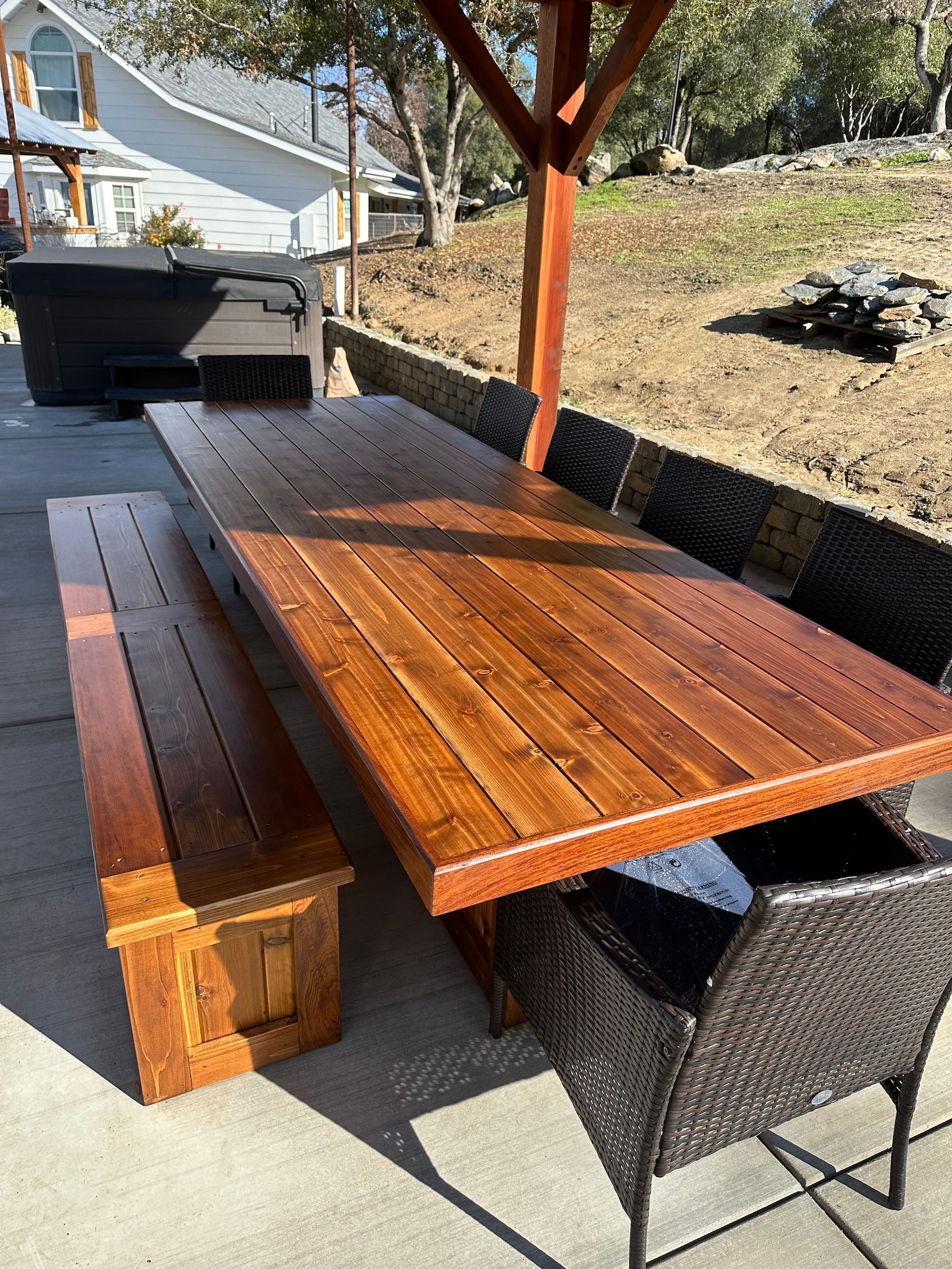a wooden table with benches and chairs on a patio .