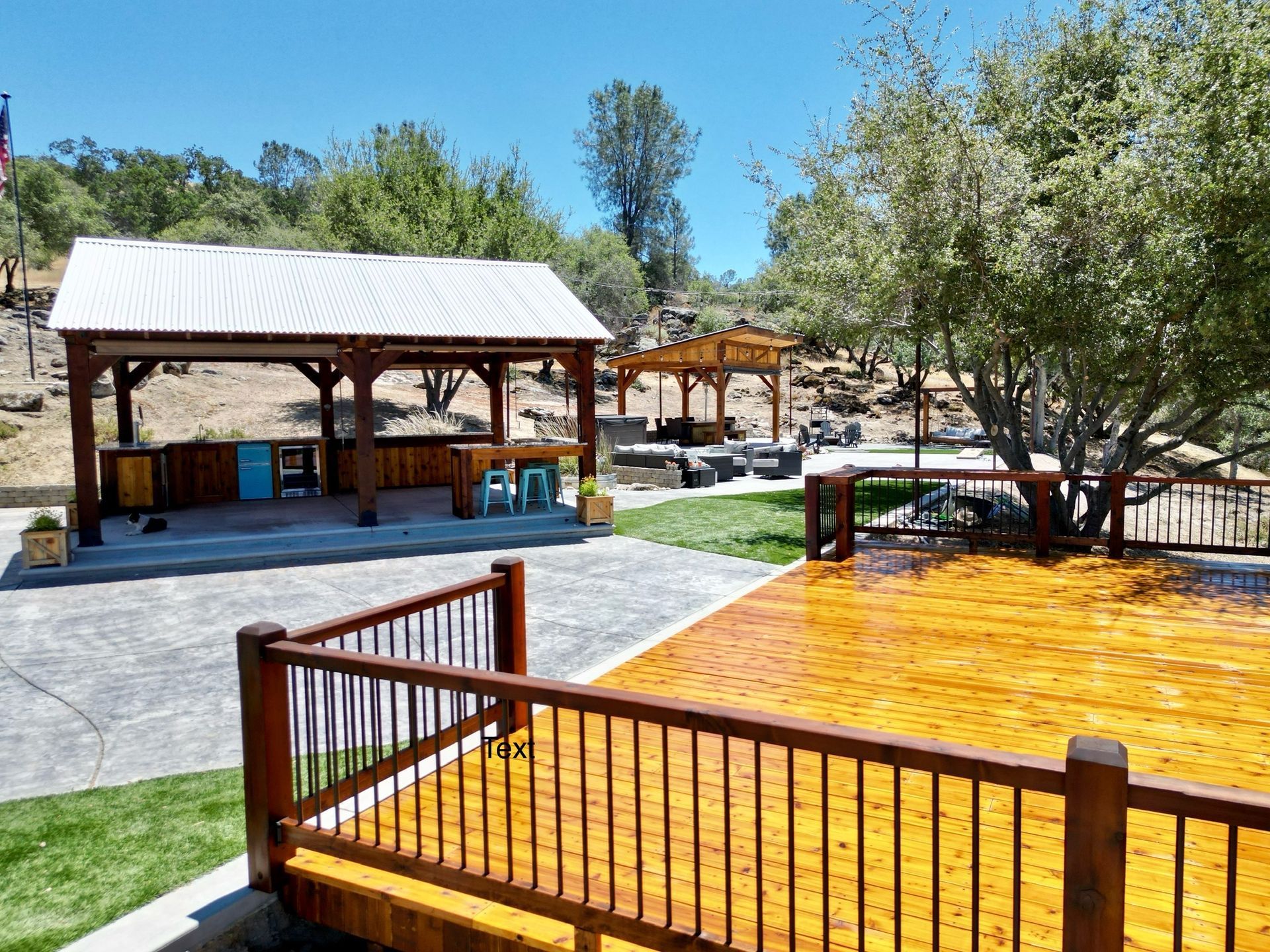 A wooden deck with a fence and a gazebo in the background.