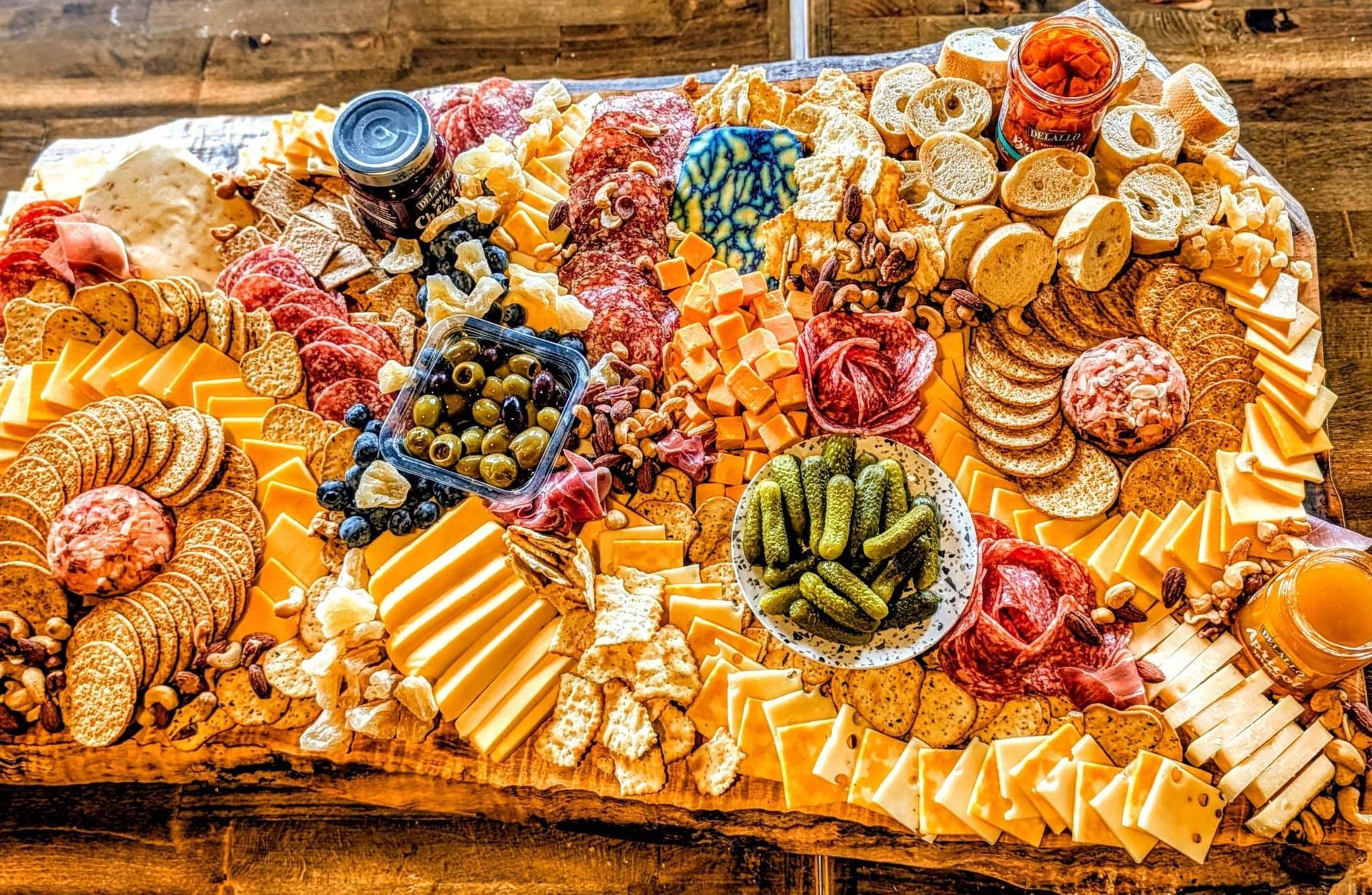 charcuterie board with cheese, fruit, crackers, and sliced 