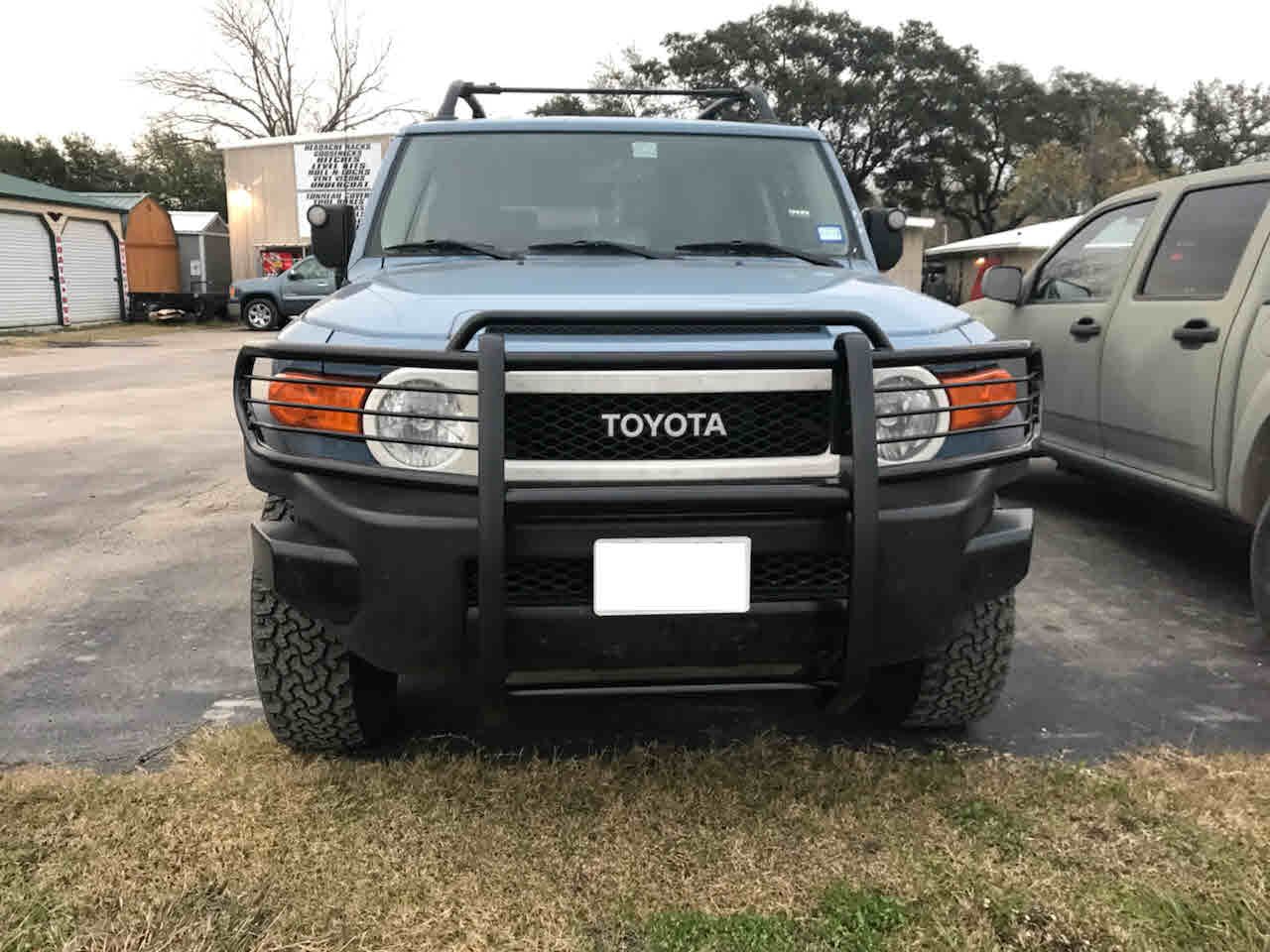 A toyota fj cruiser is parked in a grassy area.