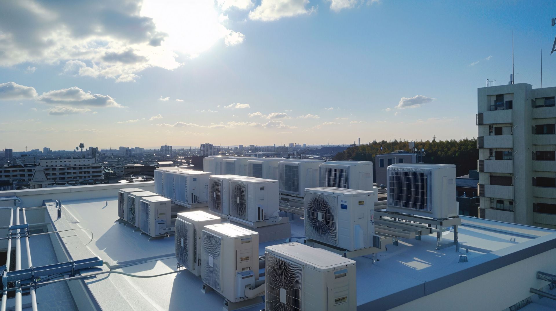 Il y a beaucoup de climatiseurs sur le toit d'un immeuble.
