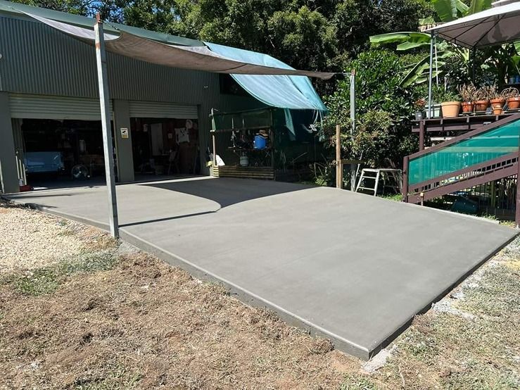 A Concrete Driveway Is Being Built In Front Of A Garage — B & C Donnachie Concrete Contractors in Kuranda, QLD