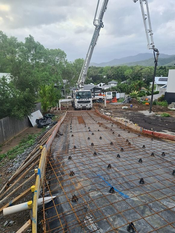 A Concrete Pump Is Being Used To Pour Concrete On A Construction Site — B & C Donnachie Concrete Contractors in Mareeba, QLD
