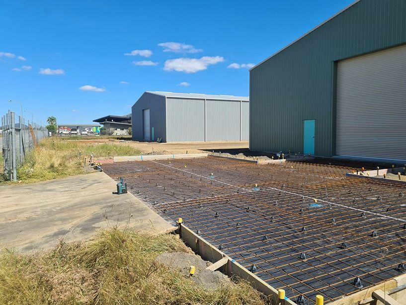 A Concrete Slab Is Being Poured In Front Of A Building — B & C Donnachie Concrete Contractors in Smithfield, QLD