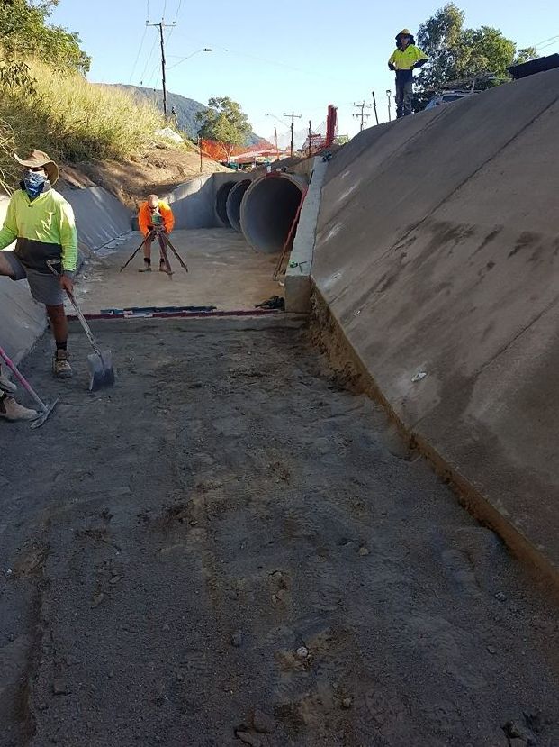 A Group Of Construction Workers Are Working On A Road — B & C Donnachie Concrete Contractors in Smithfield, QLD
