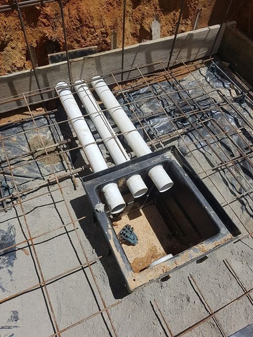 A Bunch Of Pipes Are Sitting In A Hole In The Ground — B & C Donnachie Concrete Contractors in Kuranda, QLD