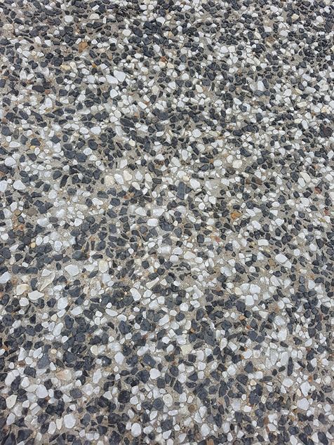 A Close Up Of A Concrete Surface With A Lot Of Small Rocks On It — B & C Donnachie Concrete Contractors in Kuranda, QLD