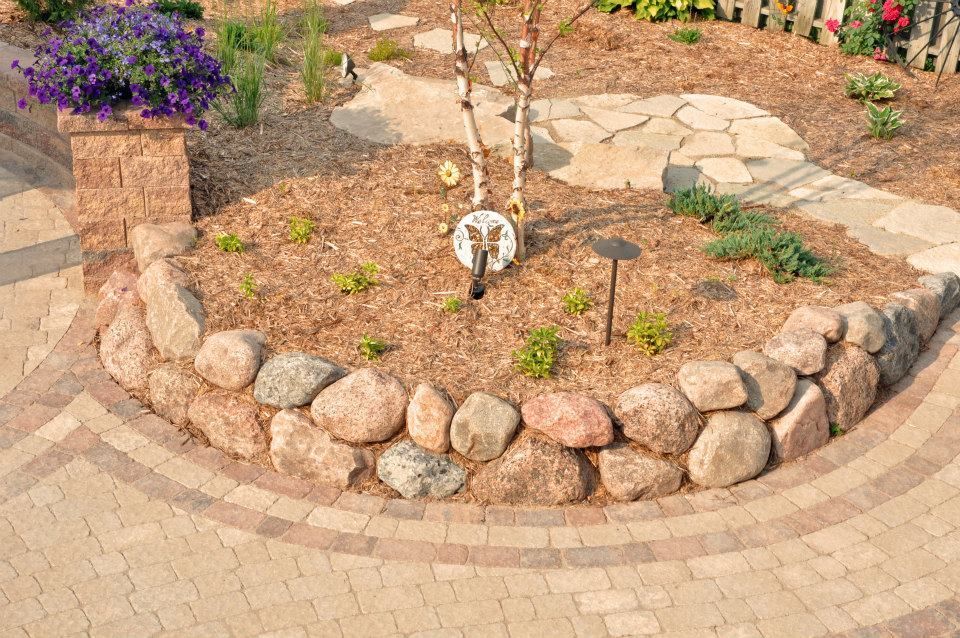 A Brick Walkway Surrounded By Rocks And Flowers In A Garden — Menasha, WI — Artscapes COC