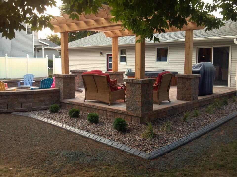 A Patio With A Pergola And Chairs In Front Of A House — Menasha, WI — Artscapes COC