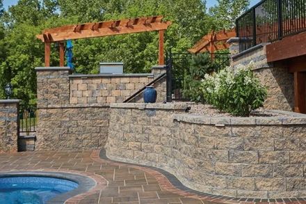 A Brick Wall Surrounds A Swimming Pool With A Pergola — Menasha, WI — Artscapes COC