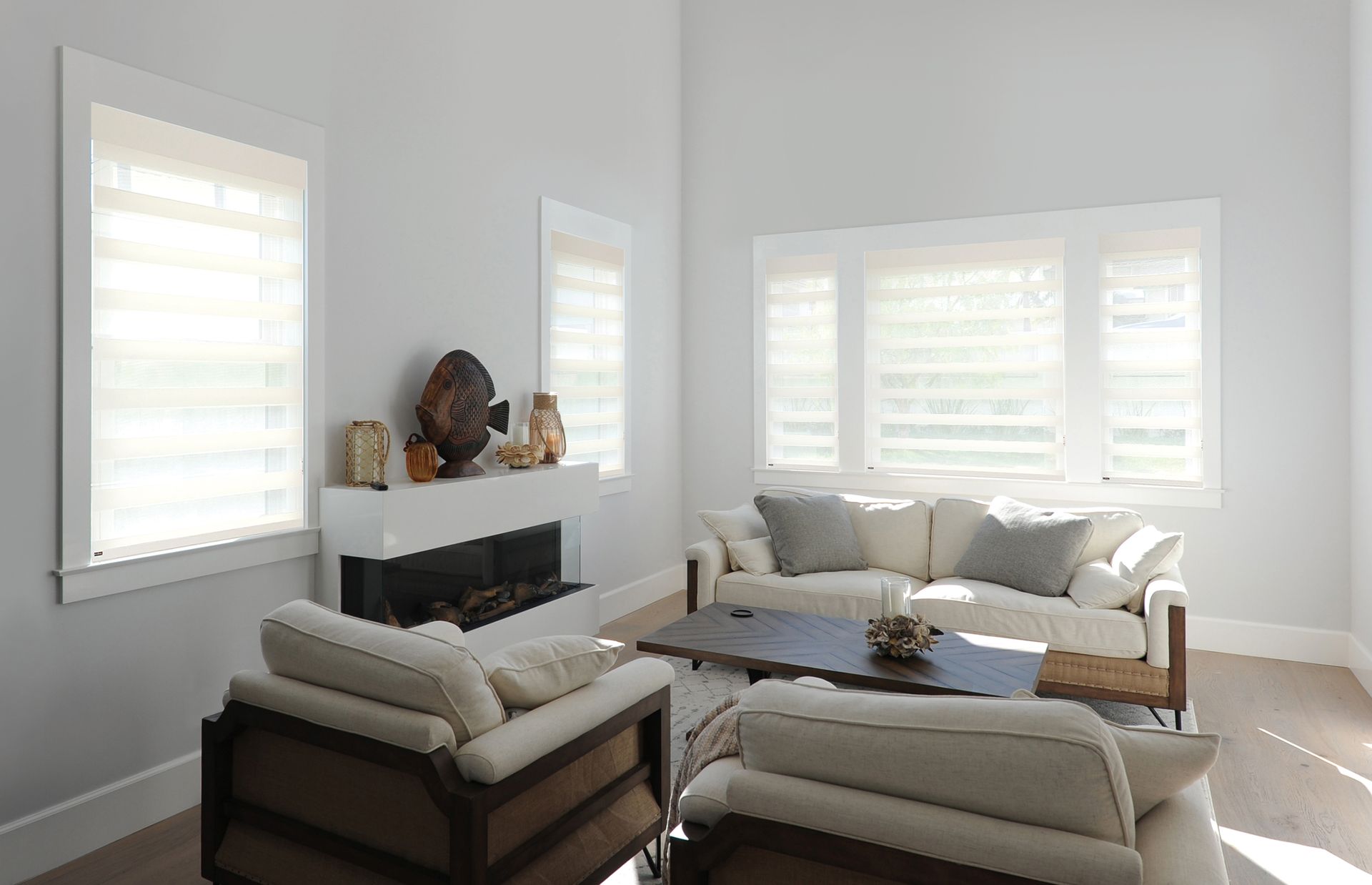 Living room with light gray walls, white trim, modern fireplace, and beige furniture.