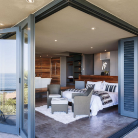 Modern luxury living room
with large folding doors opening to an ocean view.