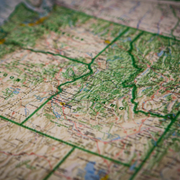 Folded topographic map with green boundary lines and terrain details in muted colors