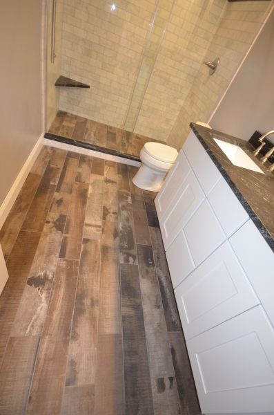 A bathroom with a toilet , sink and walk in shower.