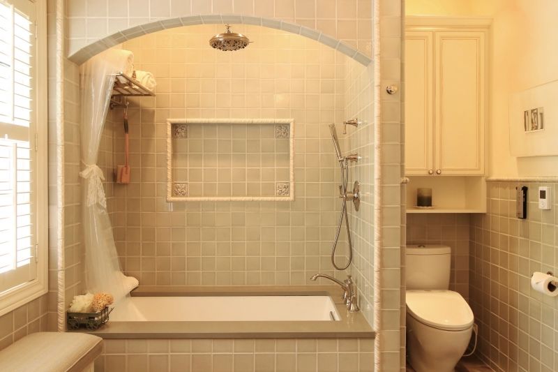 A bathroom with a tub , toilet and shower.