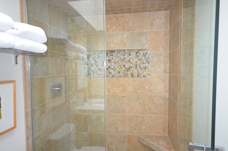 A bathroom with a walk in shower and a toilet.
