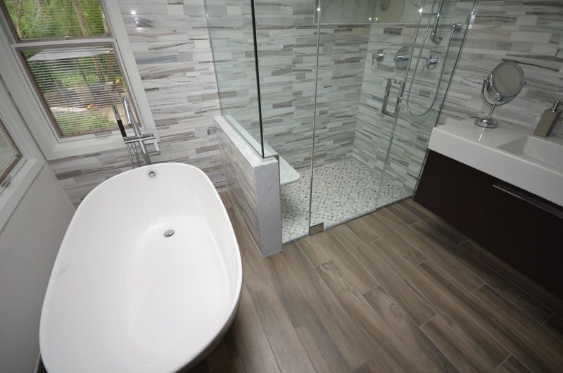 A bathroom with a bathtub and a walk in shower.