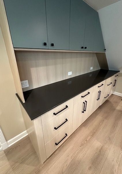 A kitchen with wooden cabinets and a black counter top.
