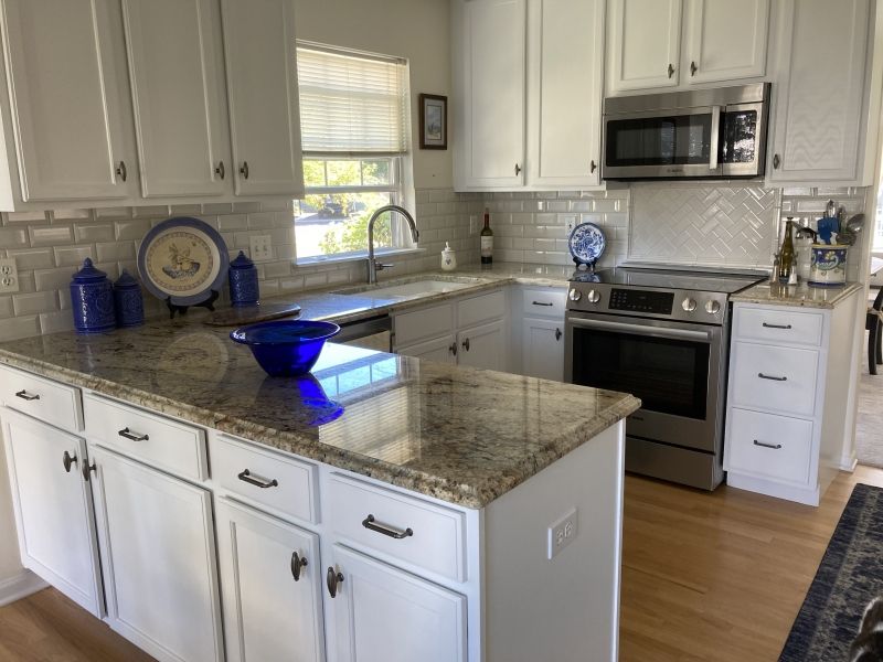 A kitchen with white cabinets and granite counter tops