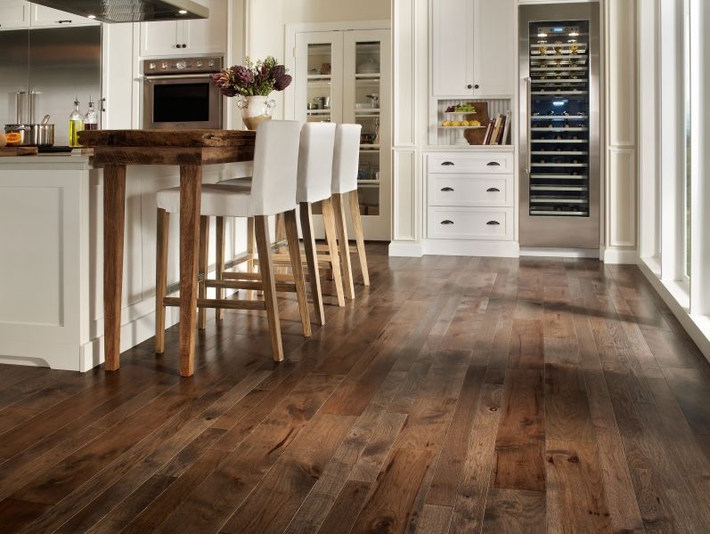 A kitchen with hardwood floors and white cabinets