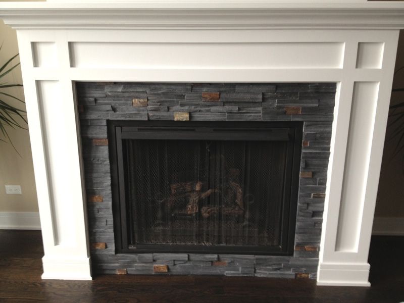 A fireplace with a white mantle and a black screen