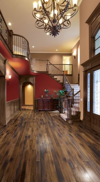 A hallway with a staircase and a chandelier hanging from the ceiling