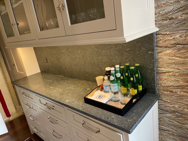 A kitchen counter with bottles of water and glasses on it