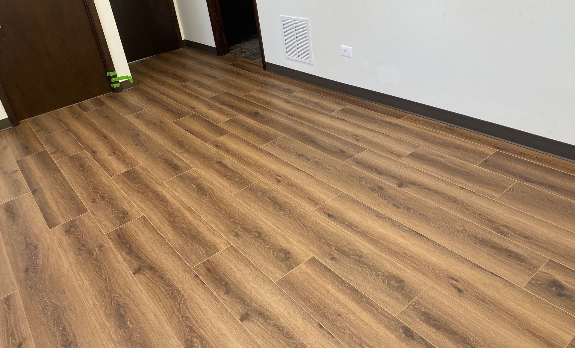 A room with a wooden floor and a door.