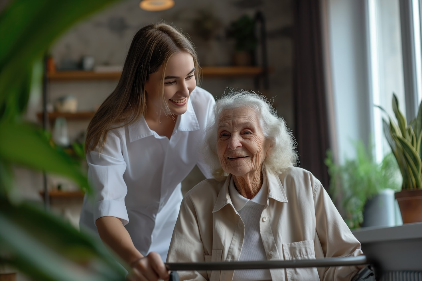 A young woman is helping an elderly woman with a walker.
